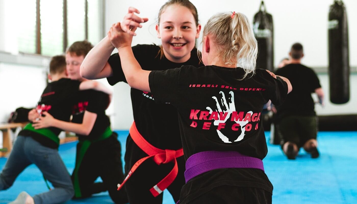 Kinder üben im Kampfsportunterricht miteinander